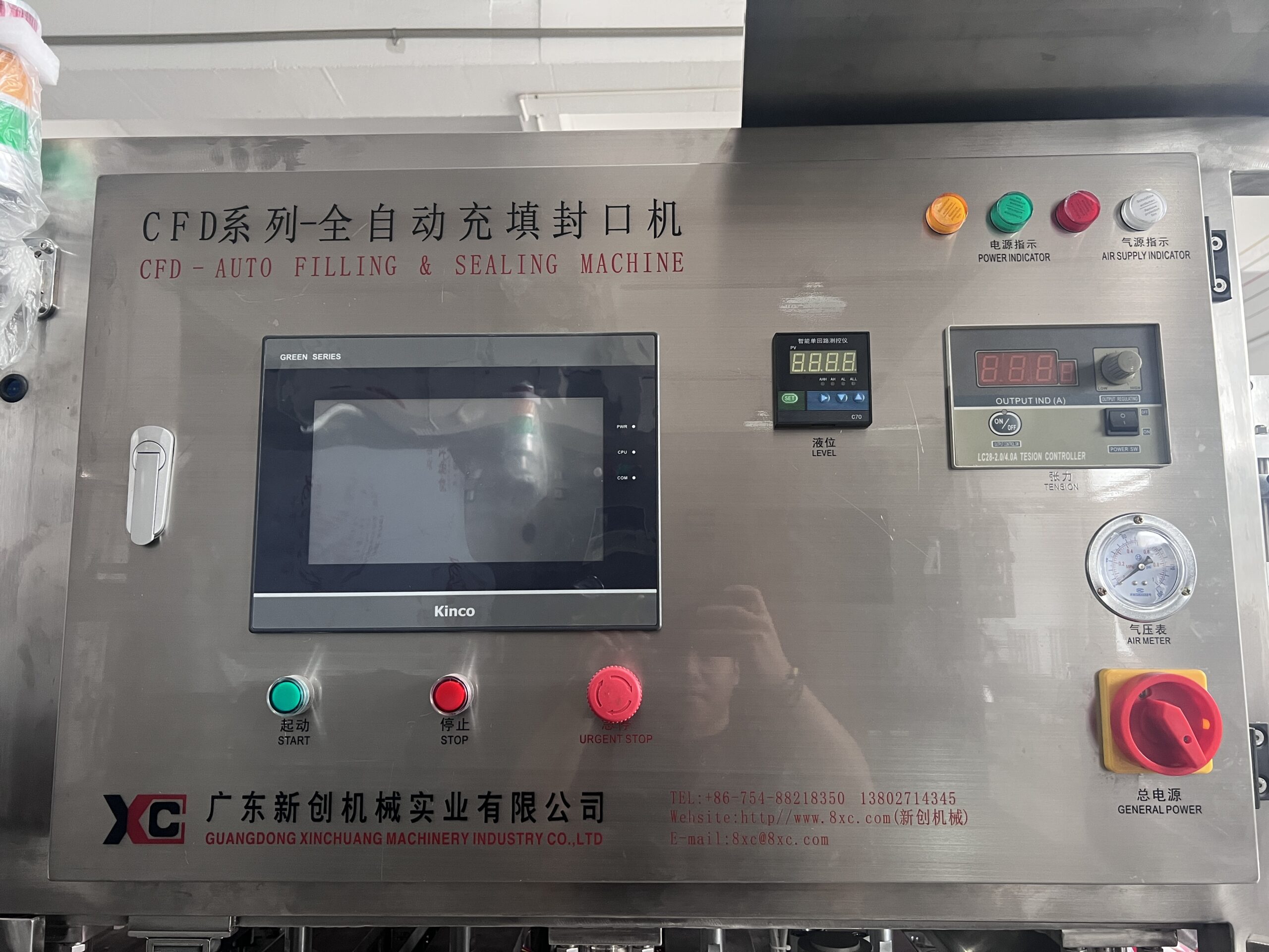 Automatic filling and sealing machine with control panel.