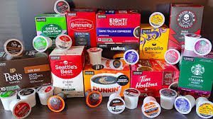 Various coffee pod brands stacked on a shelf.