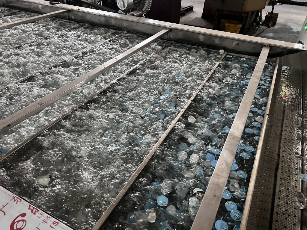 Water-filled tank with floating bottles inside