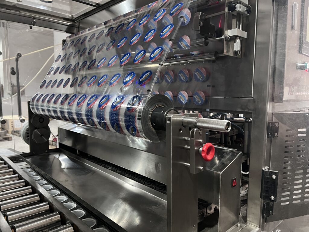 A UV lamp sterilizing a row of cups inside a filling machine