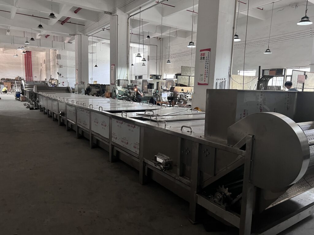 A long pasteurizer line with sealed ice lollies moving through it