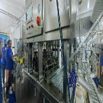 Workers operating machinery in a production facility.