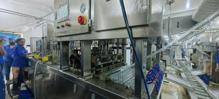 Workers operating machinery in a production facility.