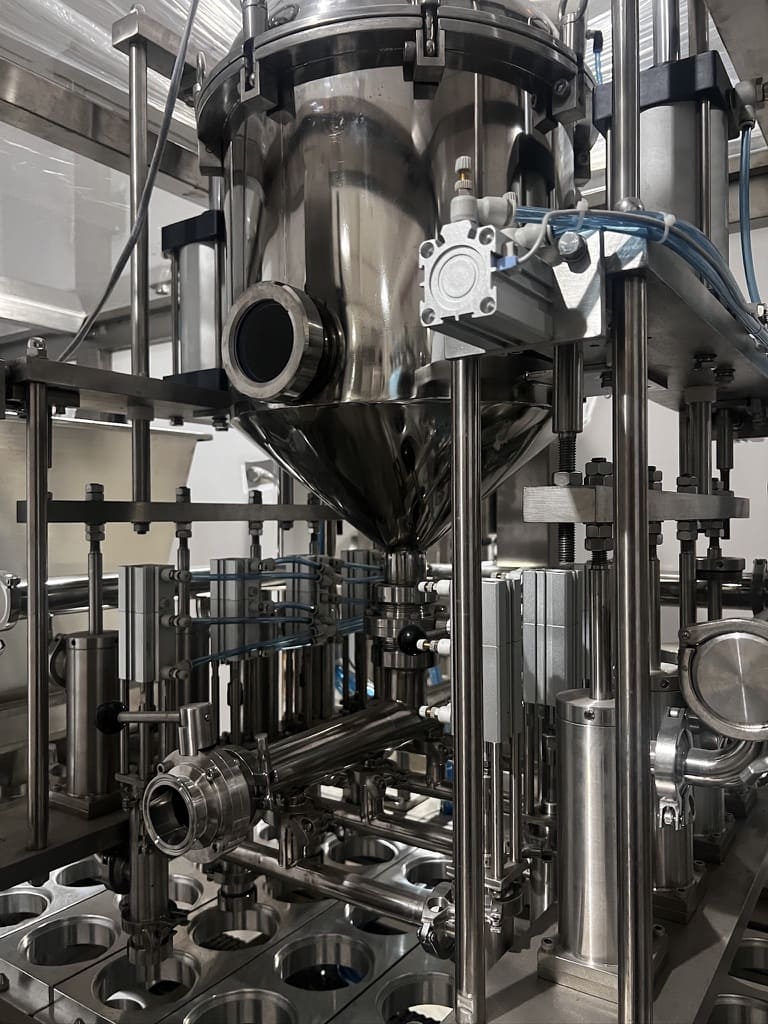 An animation or diagram showing the flow of cleaning solutions through a cup filler's system.