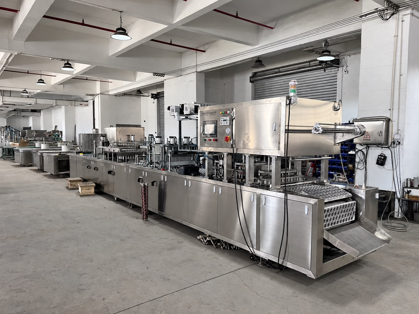 Real wide workshop view of a long automatic cup filling and sealing line