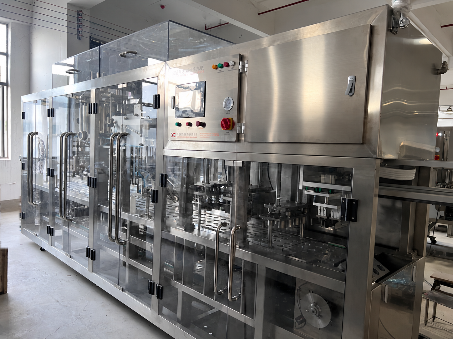 Enclosed linear cup filling and sealing equipment for yogurt and dairy