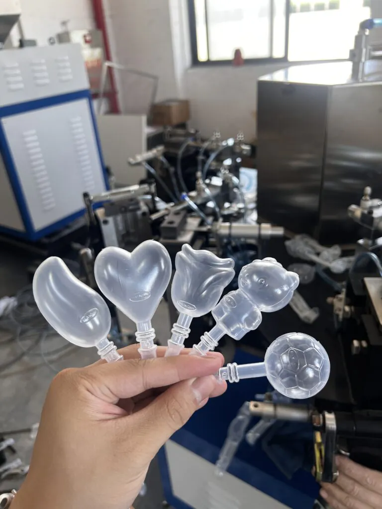 Different shapes and sizes of ice lolly tubes next to a machine part