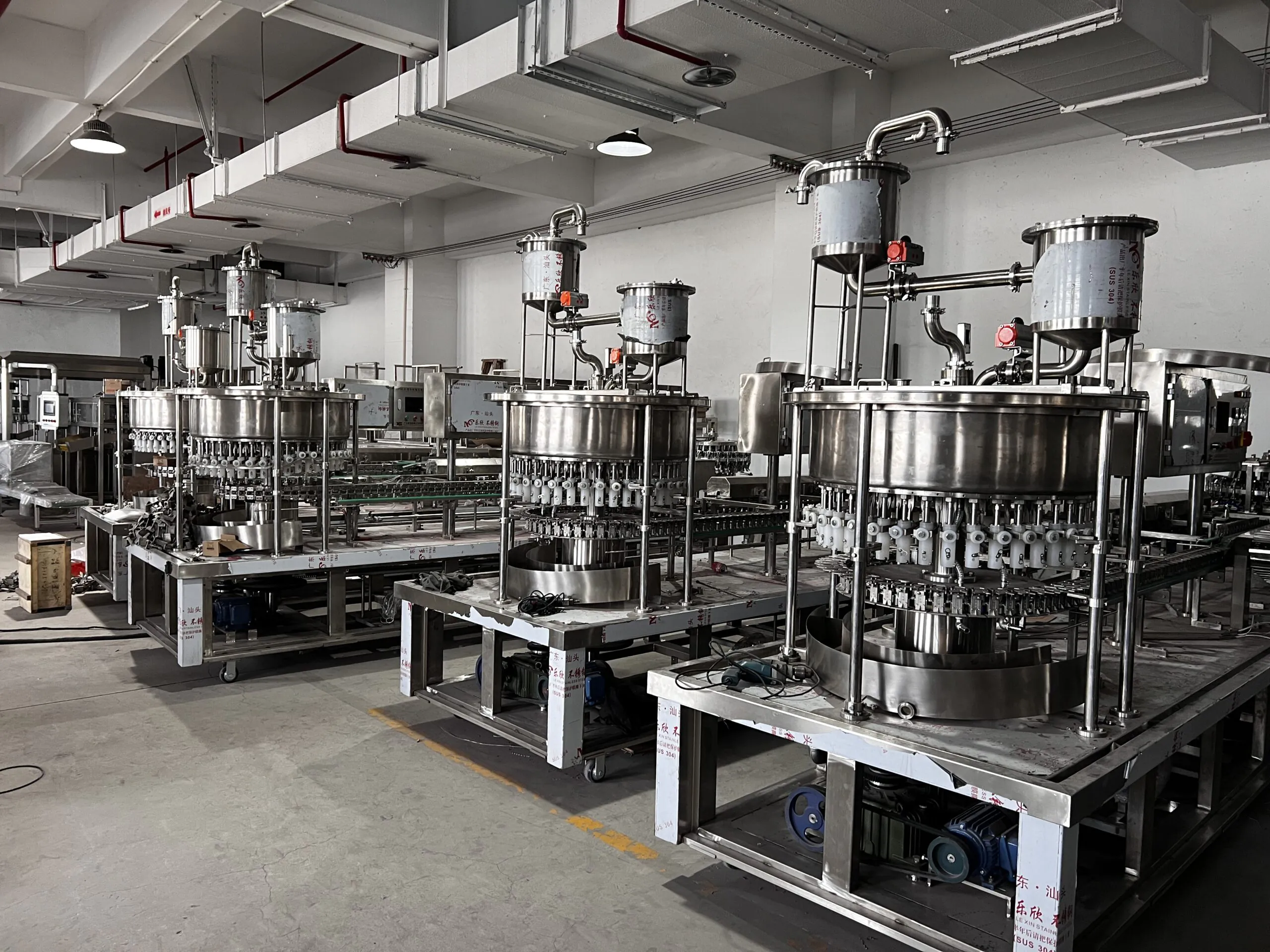 Industrial beverage filling machines in factory setting.