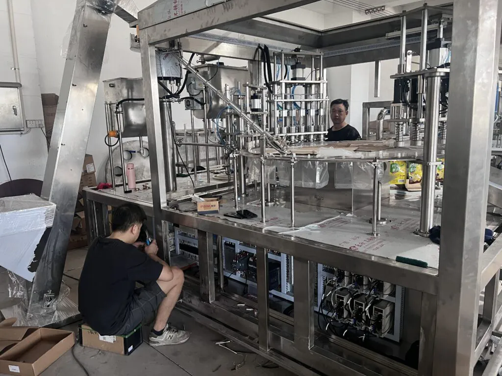 Workers assembling industrial machinery in a factory.