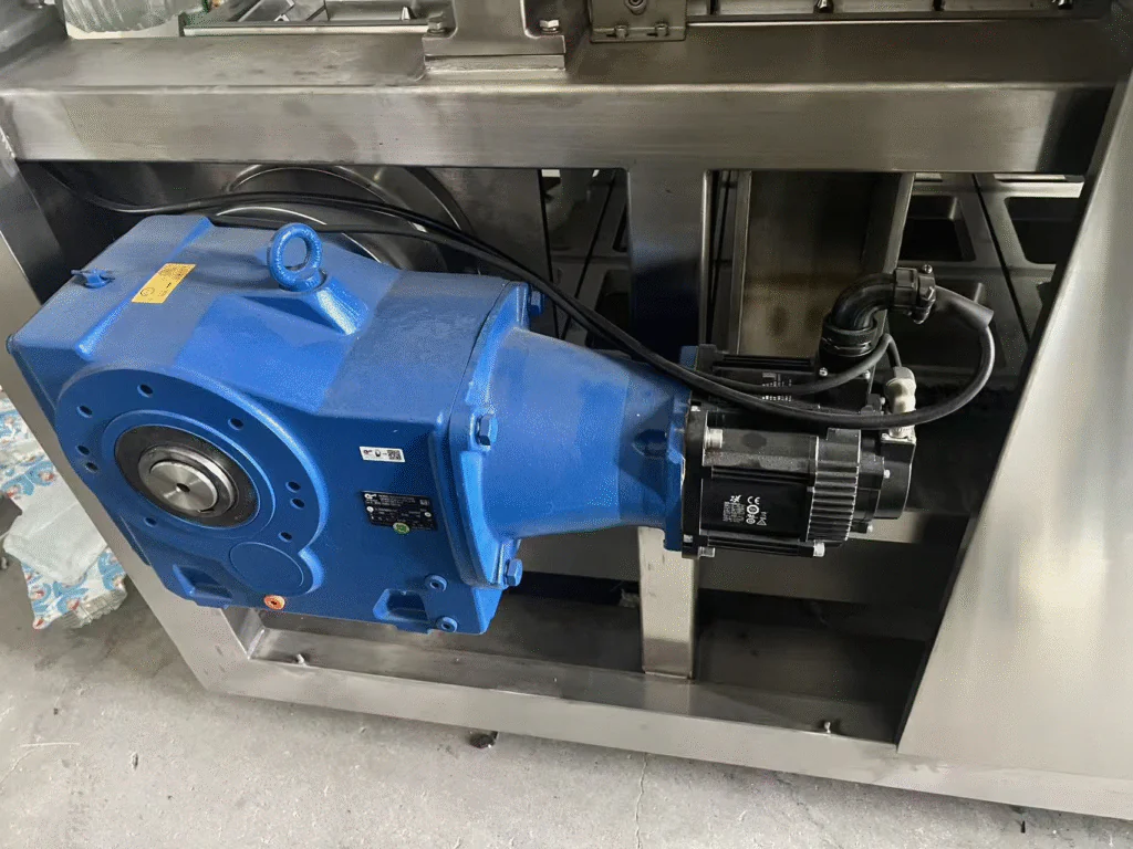 A close-up of a servo motor inside a Xinchuang Machinery cup filling and sealing machine